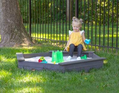 child playing with toys in jack and june hexagonal sand box